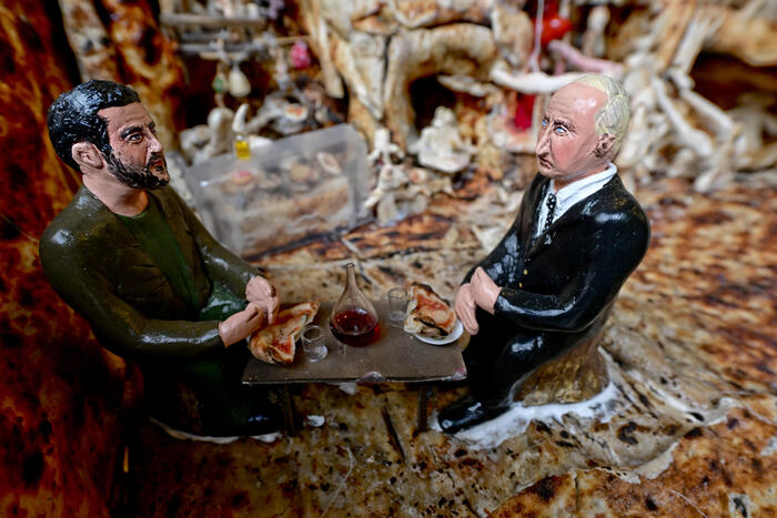 Putin e Zelensky mangiano pizza insieme. Statuette di San Gregorio come augurio per la pace
